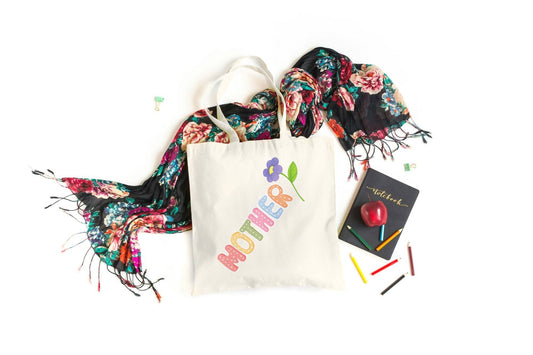 Colorful Mother Tote Bag with flower design, styled with floral scarf, notebook, and crayons. Celebrate Mom in style with this cheerful gift bag.