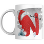 Christmas mug with red glitter letter N, Santa hat, sleigh silhouette, snowman, and pine trees. Festive ceramic drinkware for holiday gifting.