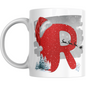 Christmas Mug with Letter R & Santa Print featuring red glitter-style R, Santa hat, sleigh silhouette, snowman, and pine trees on white ceramic.